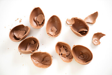 Happy Easter. Open broken destroyed crumbled chocolate eggs on a white background. Holiday.