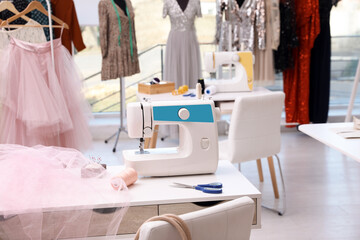 Sewing machine and equipment on table in dressmaking workshop