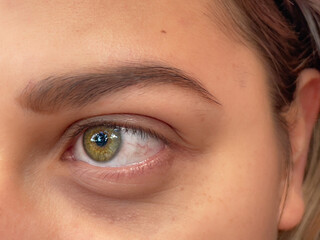 Fototapeta premium closeup of a beautiful intense yellow eye. yellow woman eye