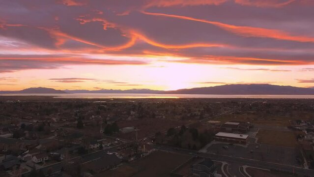 Flying over Orem city during colorful sunset looking towards Utah Lake.