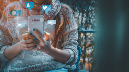 Concept with notification icons of social media on smart phone. Woman's hands holding her phone with notification icons of love, like, message, chat, comment and shopping above smartphone screen.