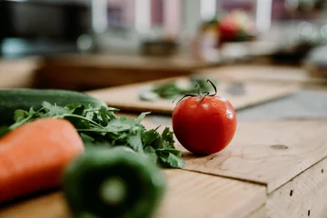 Foto op Canvas fresh vegetables ingredients for cooking on kitchen wooden counter. close up focus view on red tomato fruit on island table in home cooking place. diet healthy meal salad lifestyle concept. © PR Image Factory