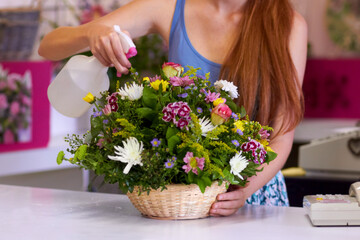 Fresh flowers just waiting to make someones day. Cropped shot of a basket of flowers being watered by a florist.