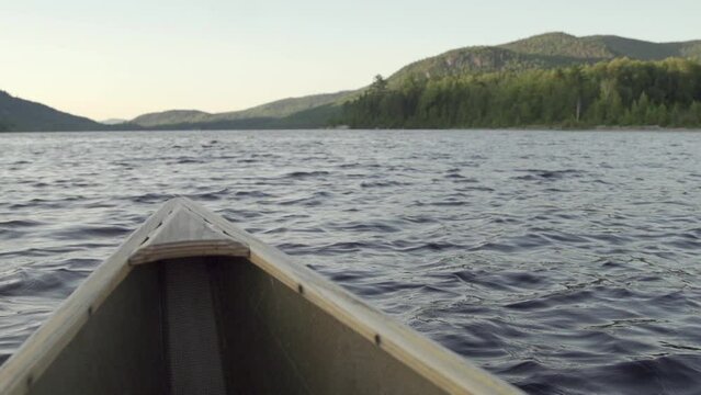 Slow motion. Close up slow motion of a wooden canoe on a lake.