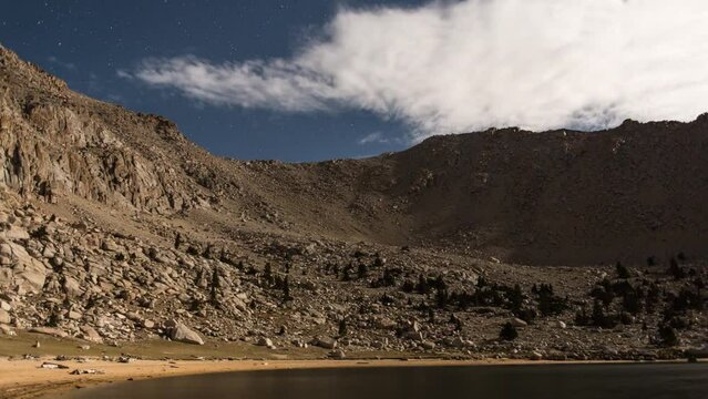 Night time lapse of an Alpine lake with mountains.