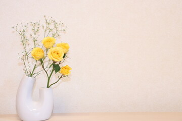 壁際の黄色いバラの花