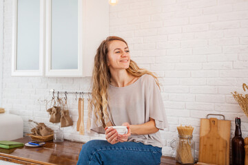 young woman in the kitchen drinking coffee