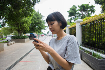Young asian woman using mobile phone in public spaces.
