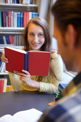 Hope I can distract him. Shot of a young man and woman studying together.