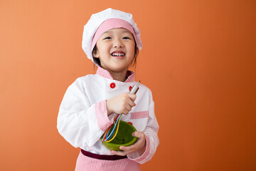 Little cute asian girl in chef costum. Concept for cooking learning for kid.