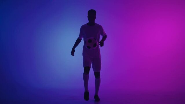 professional football player is doing kick-ups with ball and catching it, portrait of african man