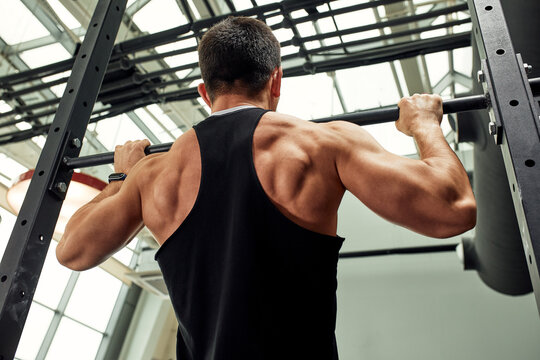 Pain during exercise, work with his own weight, the athlete does exercises on the uneven bars overcoming pain