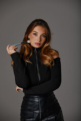 Fototapeta premium Fashion portrait of nice model woman with long healthy hair in black dress on gray background, beautiful face profile