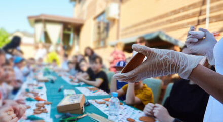 An adult hand shows a masterclass on decorating gingerbread. Delicious and creative activity for children and adults.