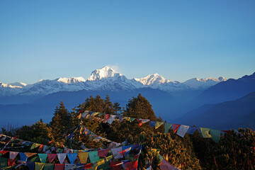 Natural landscape of Snowcapped mountain view of Poon hill with colorful prayer flags and blue sky,...
