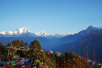 Natural landscape of Snowcapped mountain view of Poon hill with colorful prayer flags and blue sky, Annapurna Himalayan range- Ghorepani, Nepal