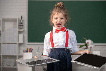 Angry girl in opposition distance education. School kid broken online laptop. Smashing damaged...