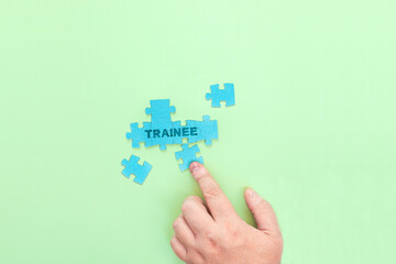 Businessman connecting puzzle pieces with the word Trainee