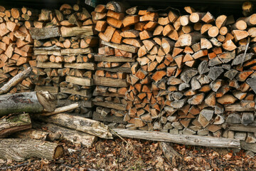 Gestapeltes Holz in Scheiten im Schuppen als Feuerholz