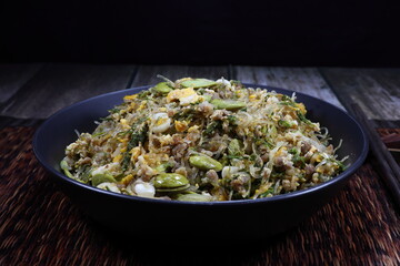 Traditional fried and stirred glass vermicelli with bitter bean serving on the bowl. Famous spicy street food menu in Asia. 