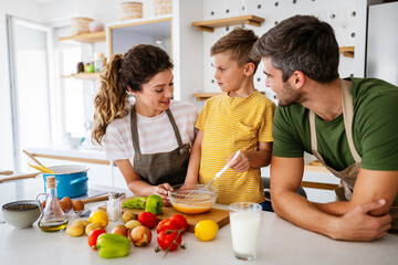 Happy family preparing healthy food together in kitchen