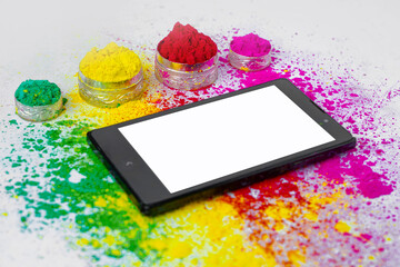 Concept of Indian festival Holi, multi color's on floors with phone and tablet