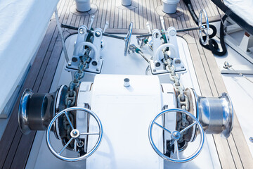 Bow part of the yacht with anchor stops, part of the anchor chain and stainless steel winches.