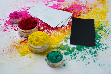 indian holi festival concept, holi colors and credit card or visiting card on white background