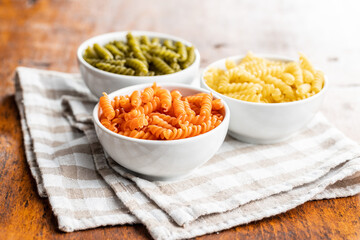 Three colors fusilli pasta. Colorful italian raw pasta in bowl.