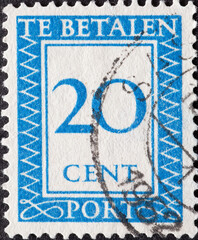 Netherlands - circa 1947: a postage stamp from the Netherlands , showing a number with an ornamental border. In blue.Text: The postage has been paid. Postage due . 20 cent
