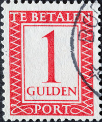 Netherlands - circa 1947: a postage stamp from the Netherlands , showing a number with an ornamental border. In red. Text: The postage has been paid. Postage due. 1 Gulden