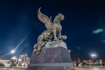 Family center and wedding palace with lighting at night, Kazan, Tatarstan. Statue of winged panther at dusk close-up. This place is landmark of Kazan. Travel concept.