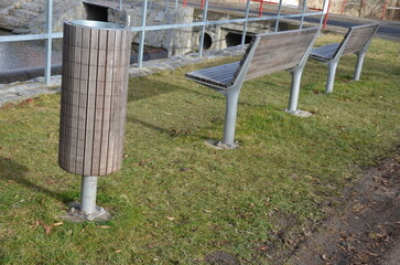 rows of reddish wood benches on their paneling under the benches is a rectangle of concrete...