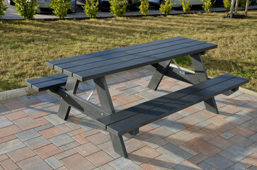 wooden seating area with benches lined with natural wood by the water. terrace by the pond with a...