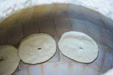 Making and baking bread in tandoor. The national way of food recipes. Production of bakery products at the factory.