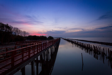 Sunrise and beautiful sky background at wooden red bridge over the sea at Gulf of Thailand, near by...