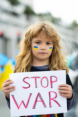 Young child in a protest with ukrainian flag and poster Stop war. Kids is protesting. Activism concept.