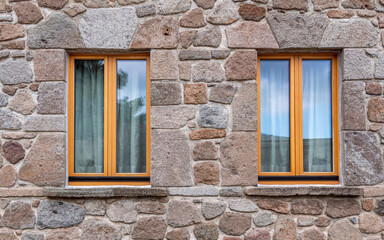 Fototapeta na wymiar Two windows isolated on rough stonewall, some space for your text or logo