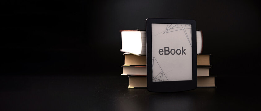 E reader. Digital e book, library reader tablet with books on dark background. Online education course, E learning class and ebook digital technology concept.