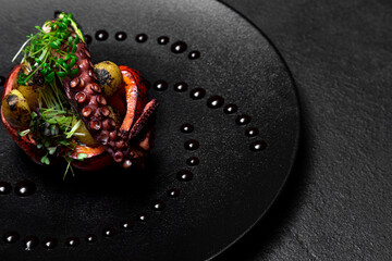 Sea delicacy grilled octopus with grilled vegetables. Dishes on a dark decorated background