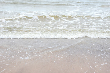 Fototapeta na wymiar Small seaside waves near shoreline in sand.