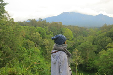 Fototapeta na wymiar A girl standing in the green landscape