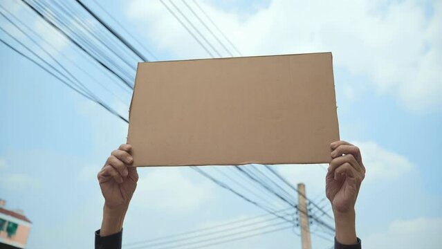 Demonstrator holding empty cardboard aloft