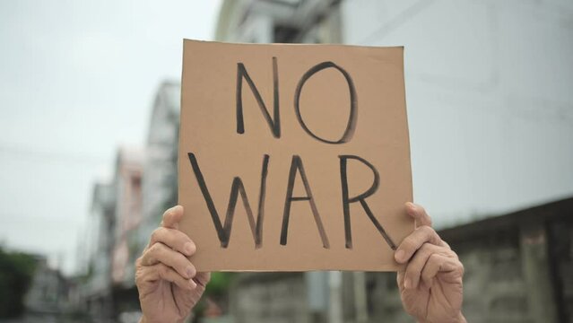 Demonstrator holding "No War" placard