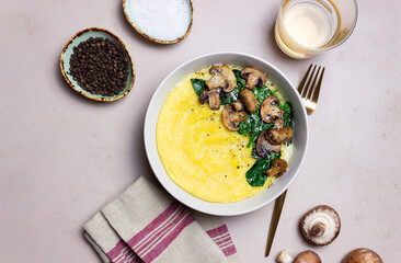 Polenta with mushrooms, spinach and cheese. Healthy eating. Vegetarian food. Italian cuisine.