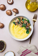 Polenta with mushrooms, spinach and cheese. Healthy eating. Vegetarian food. Italian cuisine.