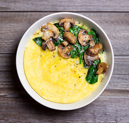 Polenta with mushrooms, spinach and cheese. Healthy eating. Vegetarian food. Italian cuisine.