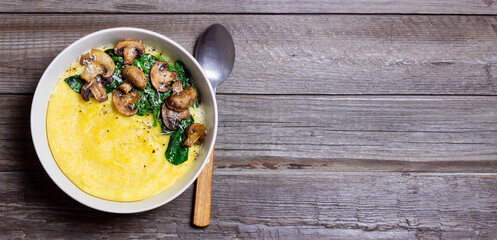 Polenta with mushrooms, spinach and cheese. Healthy eating. Vegetarian food. Italian cuisine.