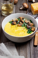 Polenta with mushrooms, spinach and cheese. Healthy eating. Vegetarian food. Italian cuisine.
