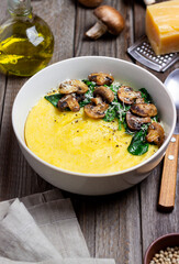 Polenta with mushrooms, spinach and cheese. Healthy eating. Vegetarian food. Italian cuisine.